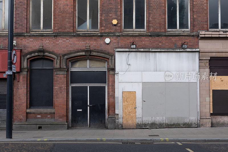 由于经济衰退，英国市中心的商店关门，用木板封起来
