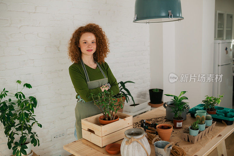 一个年轻的白人妇女的肖像照顾她的室内植物照顾