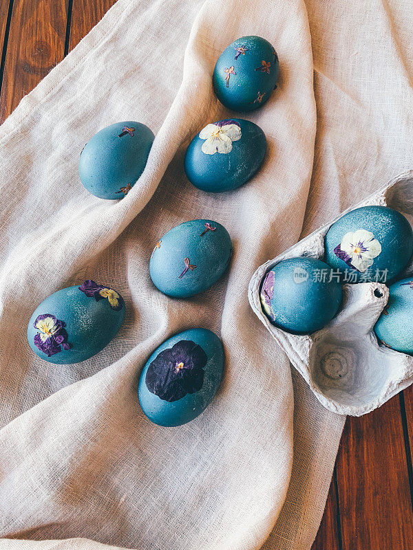 自然染色的青蓝压花复活节彩蛋鸡蛋盒在中性米色桌布背景。手工工艺，天然装饰。