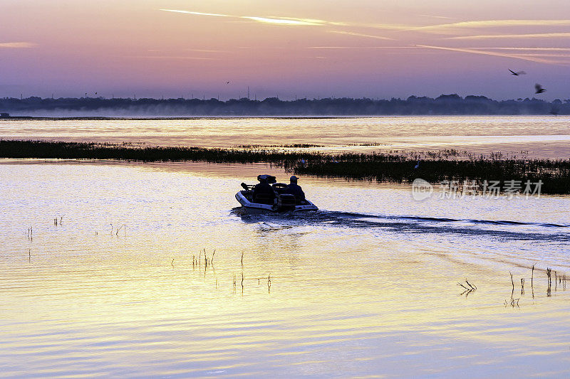 两名渔民的剪影，离开基西米码头，乘坐他们的鲈鱼船，在佛罗里达州中部的托霍湖进行清晨的钓鱼冒险