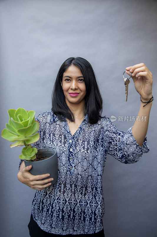 女人拿着植物和钥匙