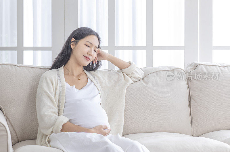 孕妇手摸肚子坐着休息