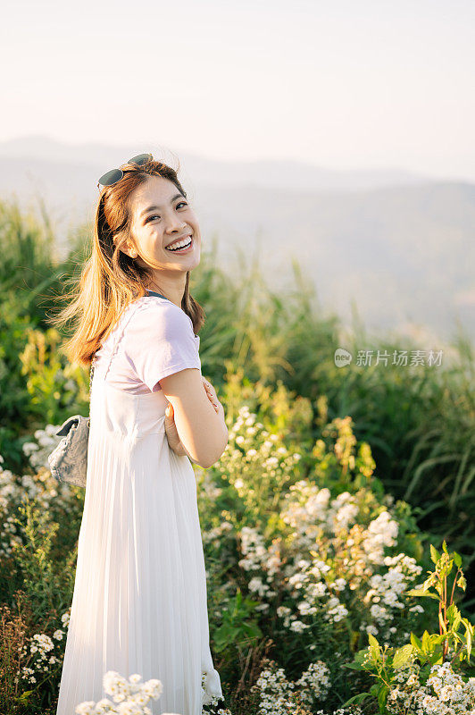 亚洲美女呼吸着新鲜的空气，与美丽的黄花田快乐