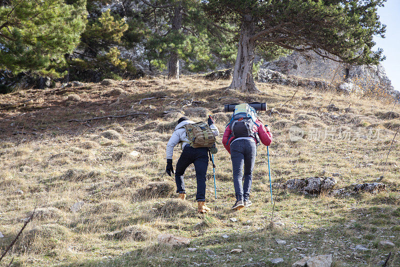 背着背包的徒步旅行者在山上度过时光的后视图