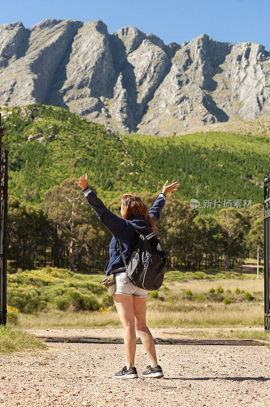 一位中年阿根廷妇女在山前举手