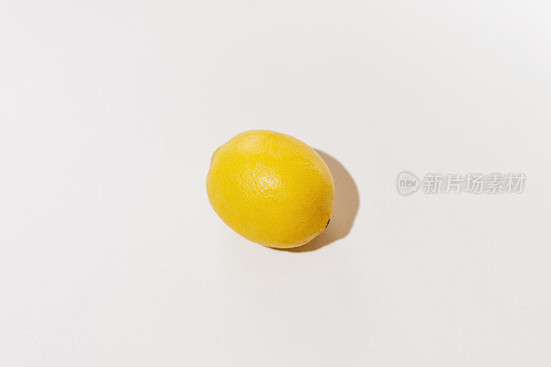 黄色柠檬被强烈的日光照射在白色孤立的背景上。图像为您的设计。化妆品原料