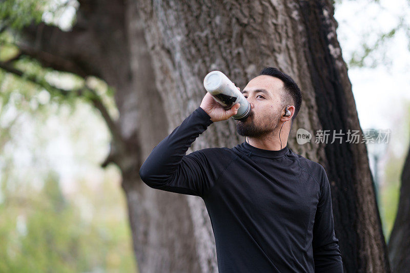 男人做户外运动保持健康，多喝水