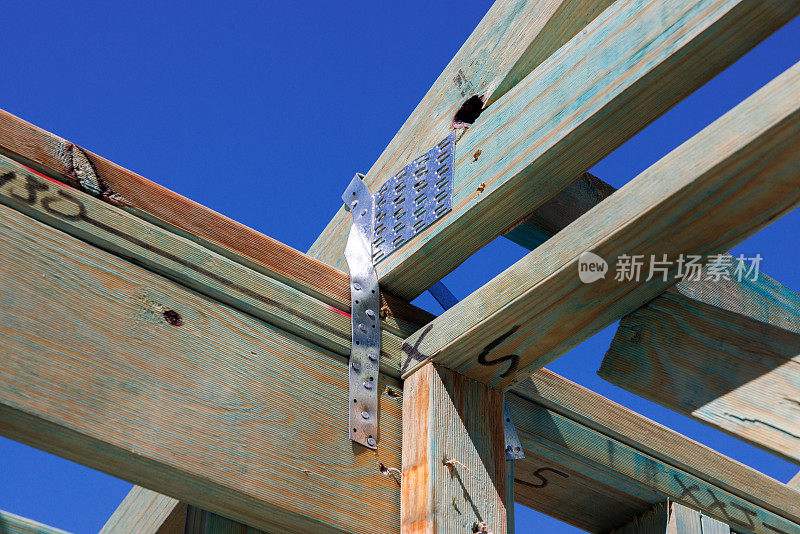 住房建设。木材屋顶框架细节。带钢旋风带的邮寄板。