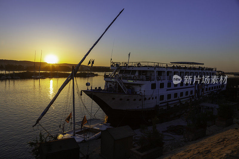在埃及的阿斯旺，尼罗河上的船只和日落。