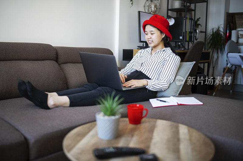 中国妇女在家里用笔记本电脑进行网上银行。