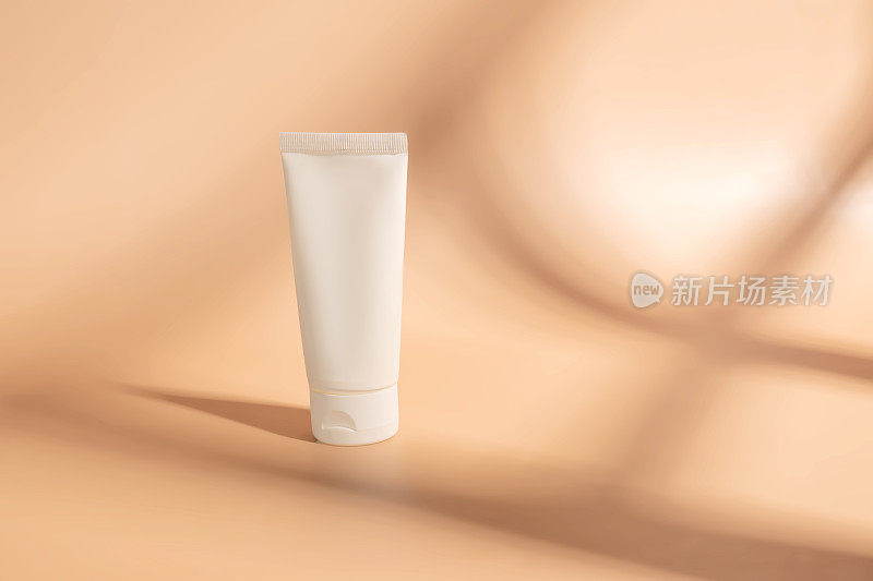 白色挤压瓶塑料管的模型，用于药品或化妆品的品牌-面霜，凝胶，护肤品，牙膏。化妆品瓶容器上的米色背景与阴影。极简主义