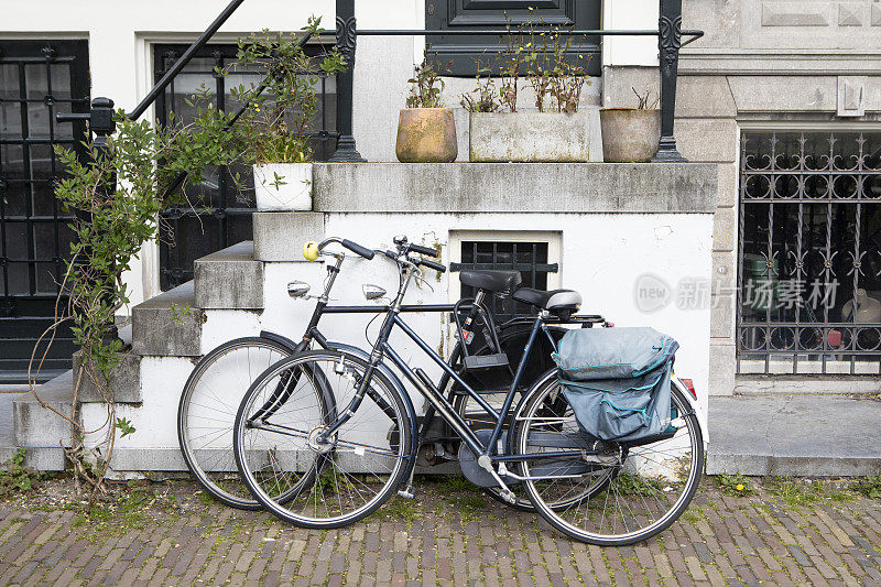 两辆自行车停在一座城市的房子外面