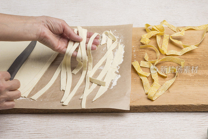 手工制作新鲜的意大利面。擀好的面团，切成条状。