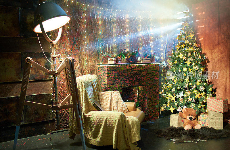 舒适的圣诞传统装饰，假壁炉，扶手椅和金色圣诞树