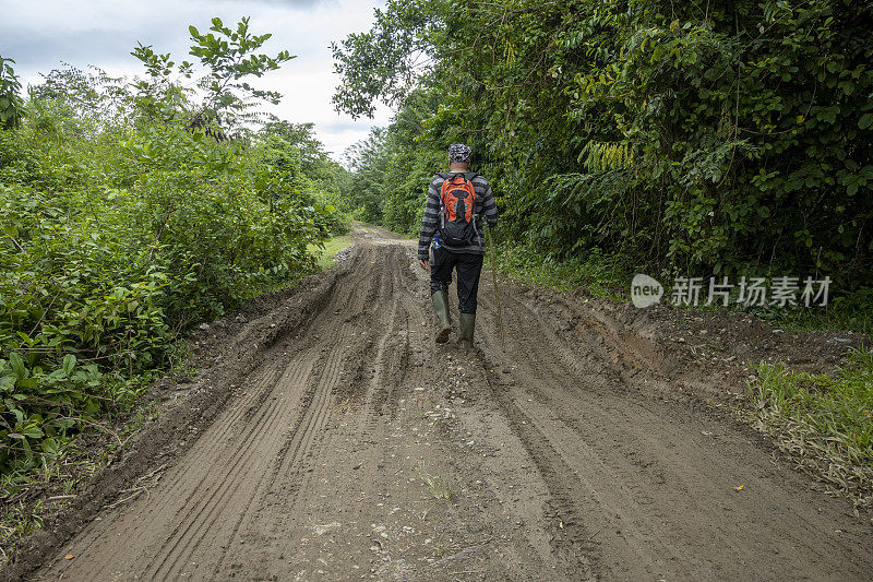 男子走在泥泞的道路-股票照片