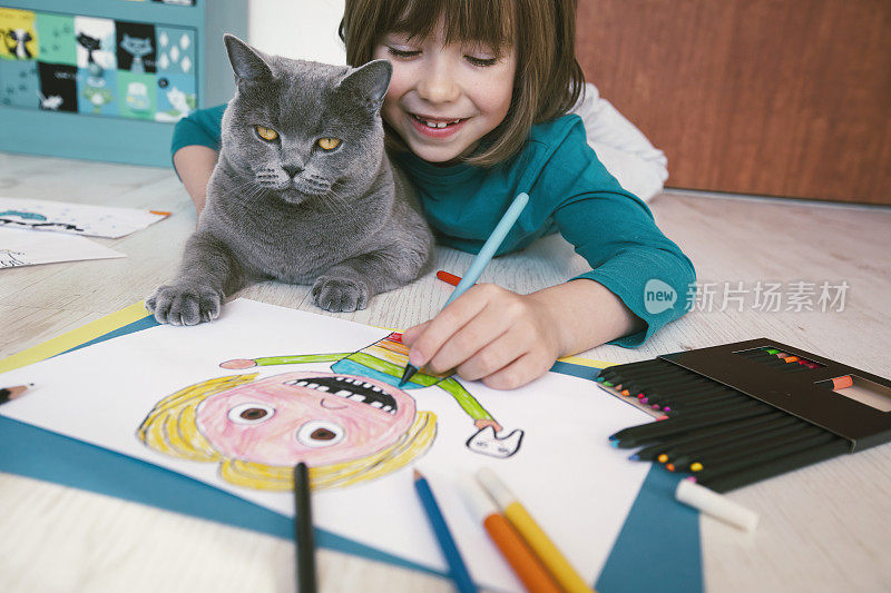 缺牙的可爱男孩在画自画像。他旁边的猫