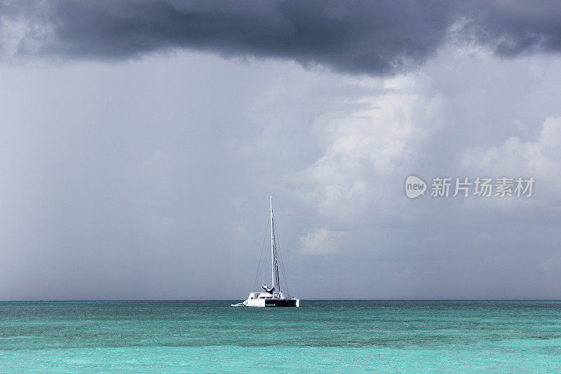 加勒比海即将来临的风暴。蓝绿色的水，白色的船和暴风雨的云。