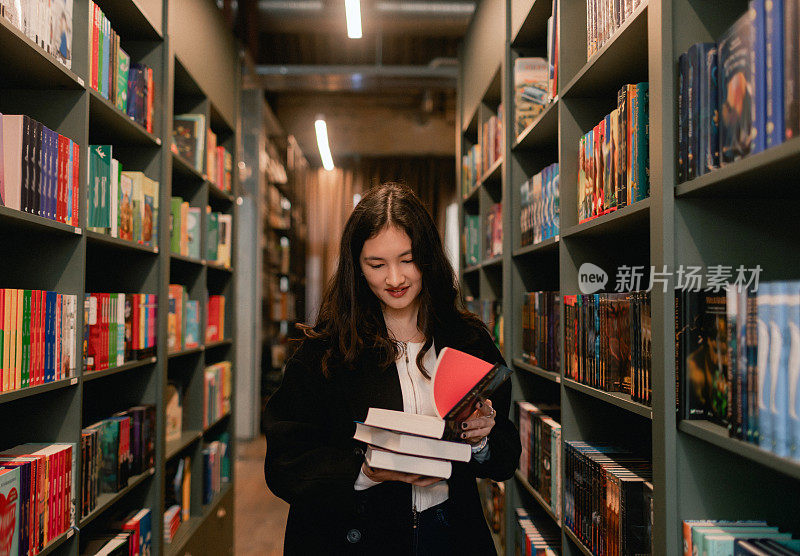 漂亮的Z代韩国女学生在书店里挑选书。教育培训理念。系列的一部分