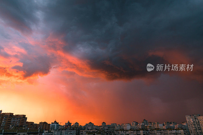戏剧性的暴风雨多云的天空在红色日落色调的现代住宅区。