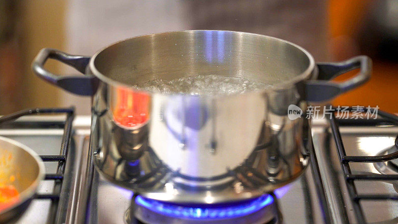 专业厨师在家庭厨房烹饪:用沸水煮番茄意面