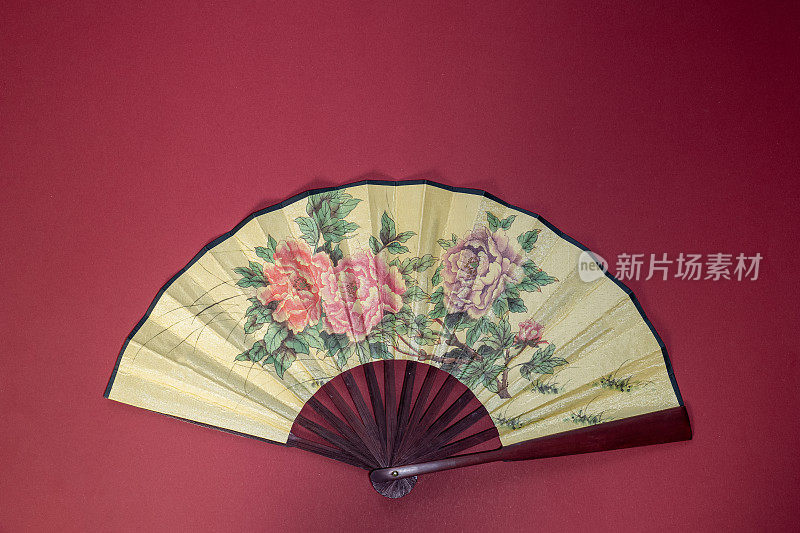 亚洲风格手持式风扇，红色背景花，中国新年主题，复制空间