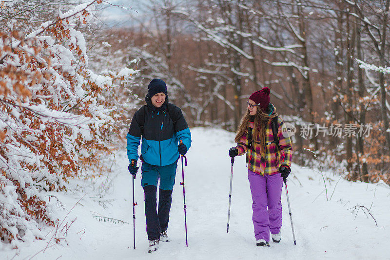 两个年轻的徒步旅行者在攀登雪山时互相交谈