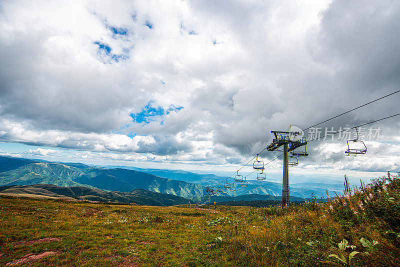 在一个阳光明媚的夏日里，有美丽的山峦和岩石景观。