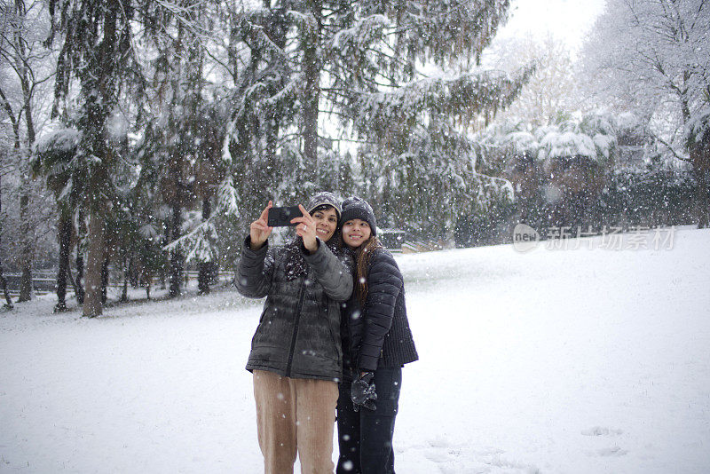 母亲和女儿在公园的雪地里