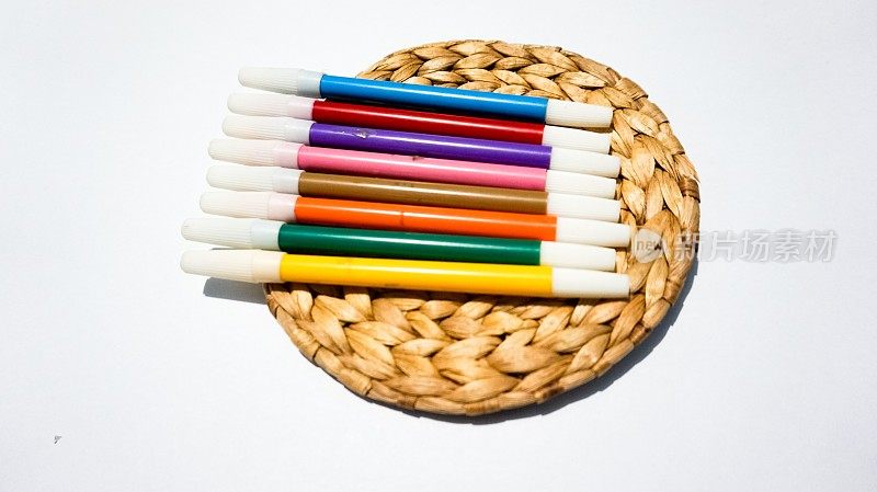 彩色笔孤立在白色背景上，在木垫上拍摄。