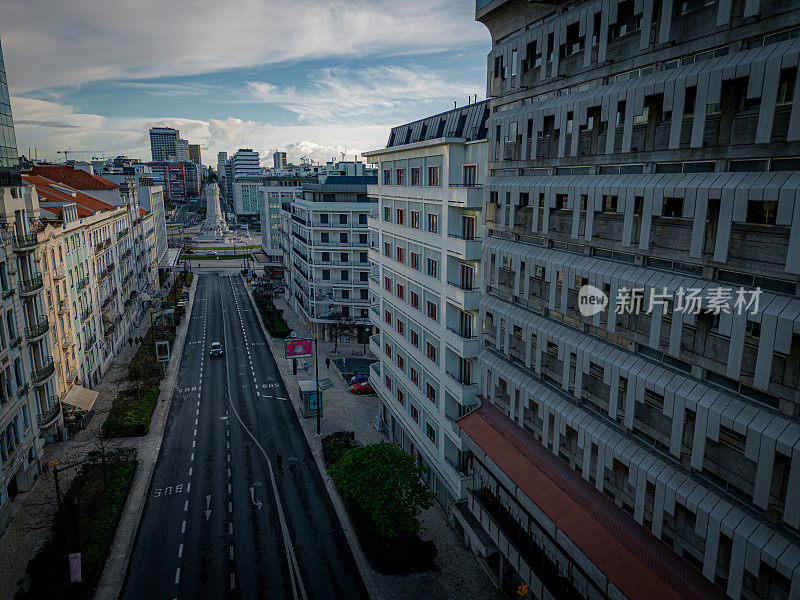 白天城市附近的航拍图像，里斯本的蓬巴尔马奎斯广场位于建筑物和街道中间