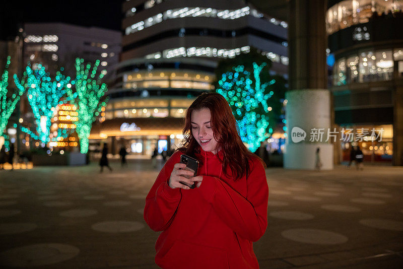 年轻的女游客在夜间拍照