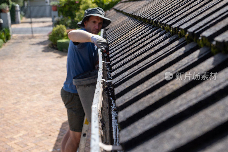 在冬雨来临之前清理屋顶排水沟里的树叶