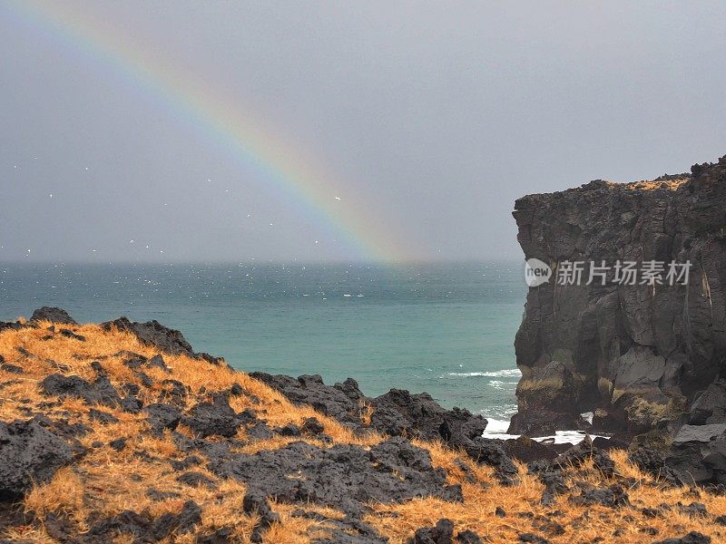 彩虹在海洋之上，在海滩上