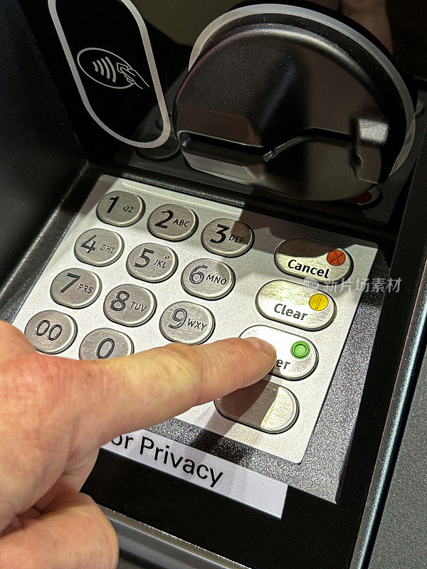 特写图像:无法识别的人用食指按下ATM键盘上的按钮，输入自动提款机密码，自动提款机读卡器和扬声器按钮，高架视图，聚焦于前景