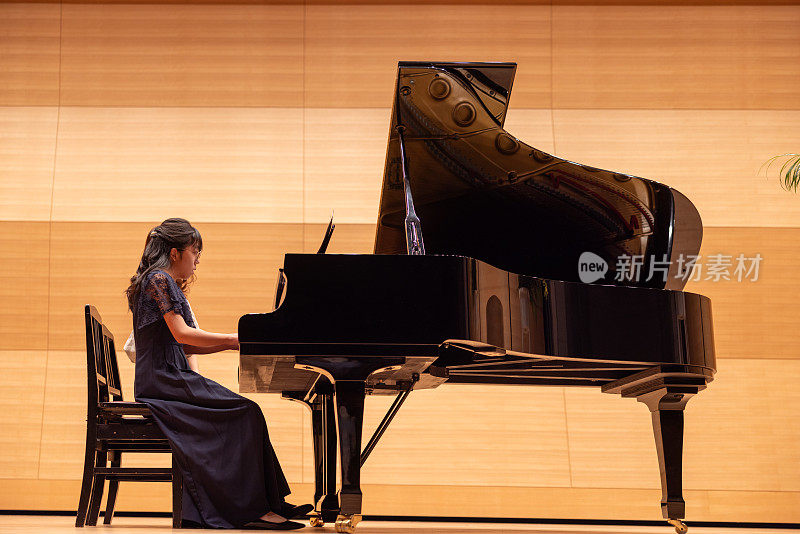 老师和学生在音乐会上一起弹钢琴