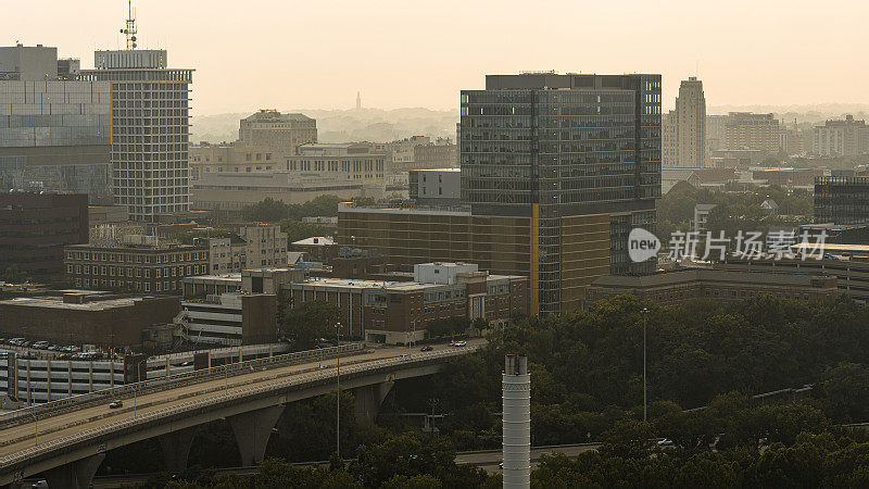 日落时分，烟雾笼罩着商业区。里士满市中心的建筑物矗立在弗吉尼亚州的城市高速公路上。鸟瞰图