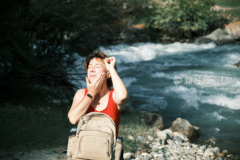 女游客在山河中洗手洗脸