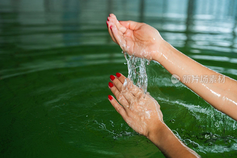 女人在热水池里用手摸水