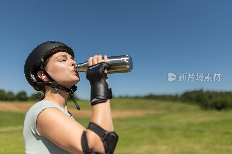 女运动员喝水解渴。