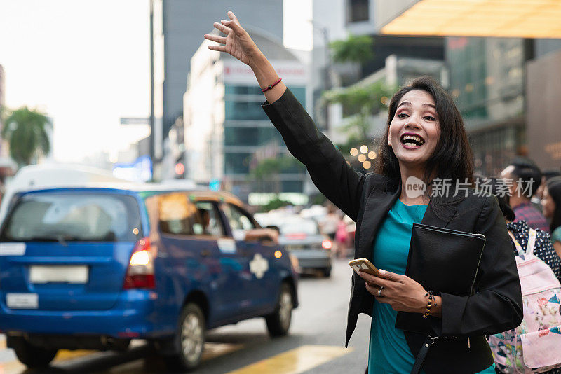 吉隆坡街头，一名女子挥手招呼出租车