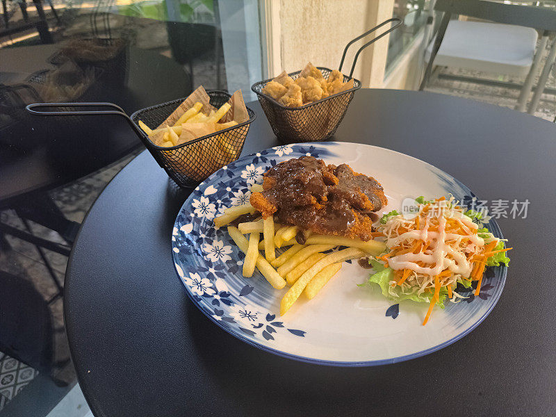 盘子里的鸡肉炸肉排。篮子里的薯条和鸡肉汽水。食品菜单。