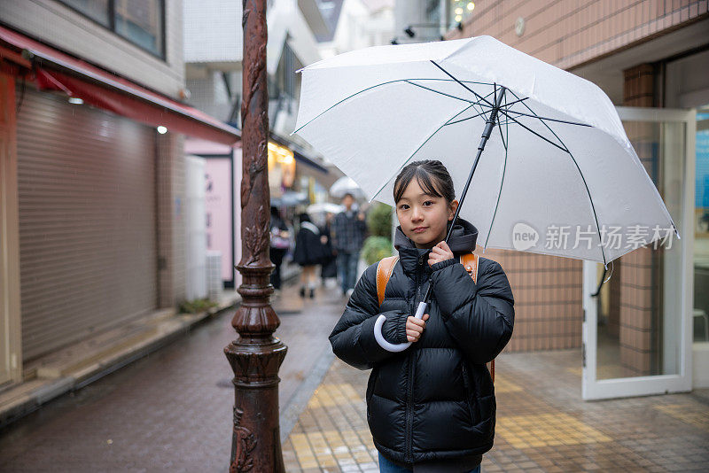 日本一名小学女生在下雨天背着一个“随机”书包