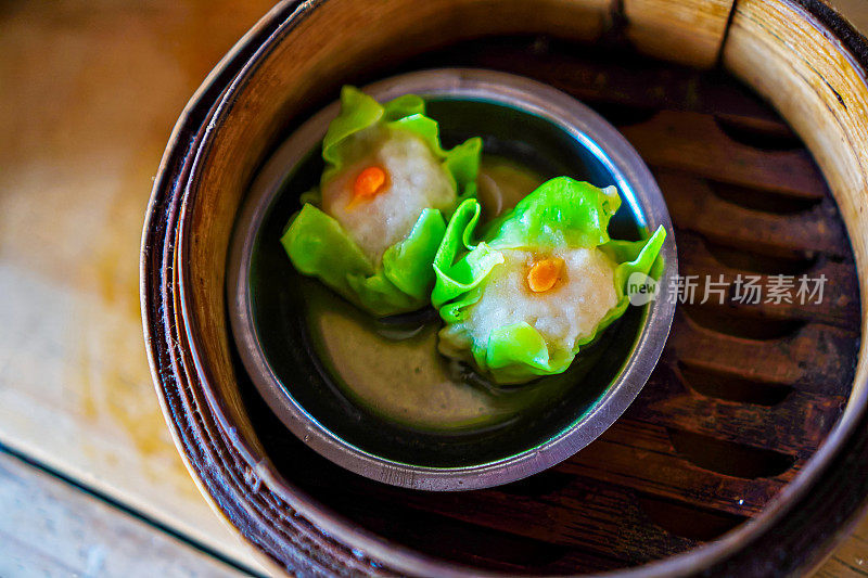 泰国点心，餐桌上的竹制蒸笼里的咸蛋虾饺特写镜头
