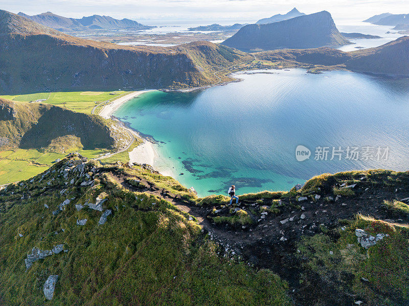 一名男子在海边的山路上徒步旅行