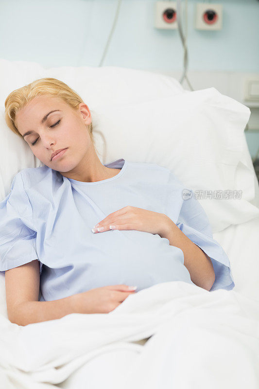 睡着的孕妇抱着肚子躺在床上