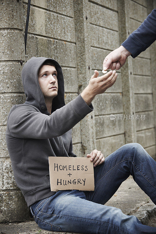 在街上给乞丐钱的人