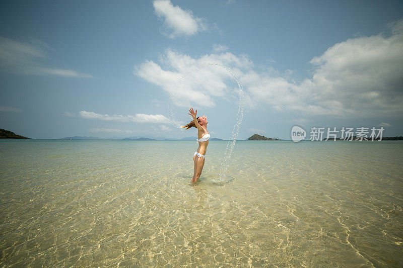 女人用头发往海里泼水