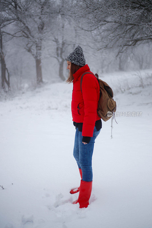 女徒步旅行者背包和雪鞋在雪地上的雪鞋