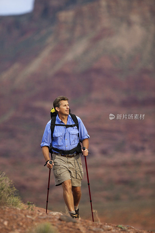 男性用登山杖在沙漠中徒步旅行