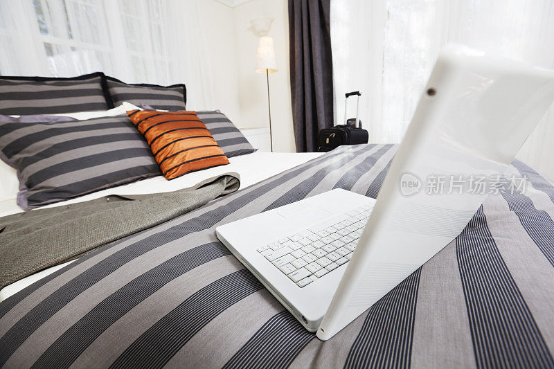 商务旅行者-笔记本电脑，夹克和手提箱在酒店房间Hz